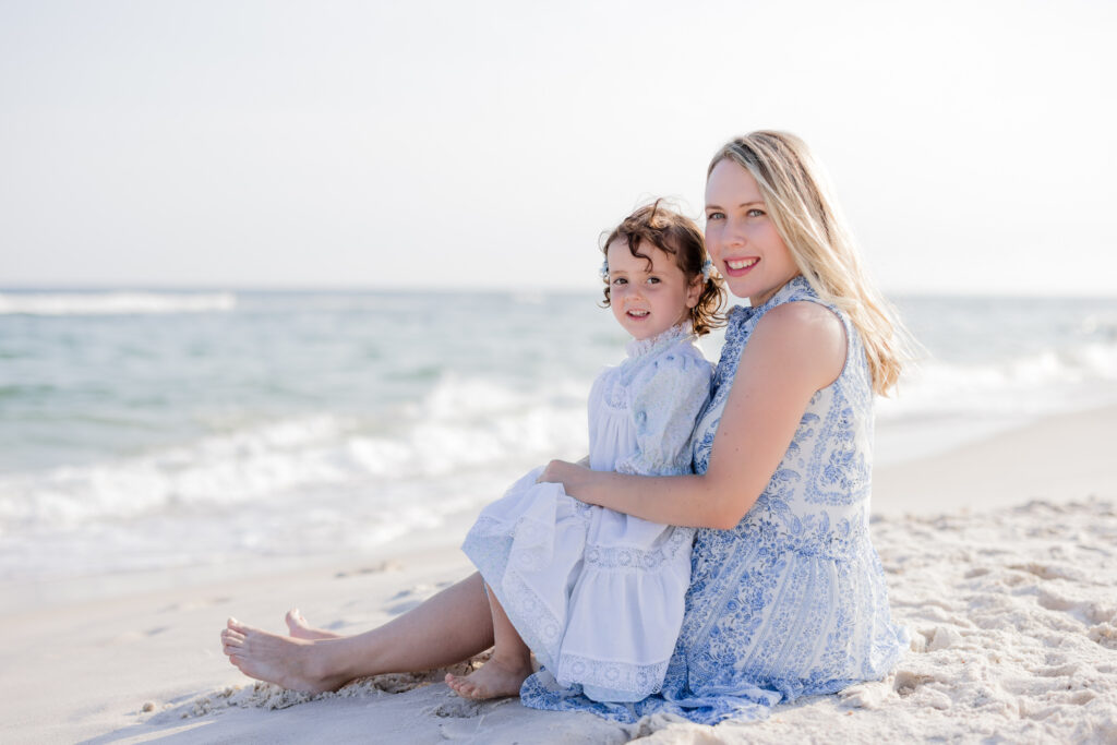 Mom and daughter wearing a blue flory dress  during their beach portraits  in Perdido Key Beach Florida